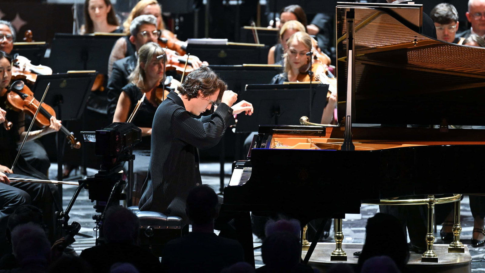 apple vision pro immersive films bbc symphony orchestra pianist lukas sternath Pianist spielt vor einem Orchester bei Konzert.